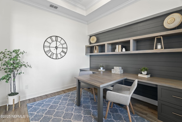 office with ornamental molding, visible vents, built in study area, and dark wood-style floors