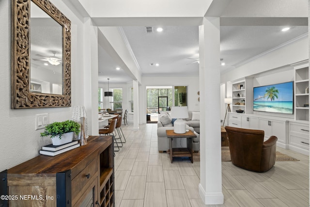 living area with visible vents, a ceiling fan, crown molding, a textured ceiling, and recessed lighting