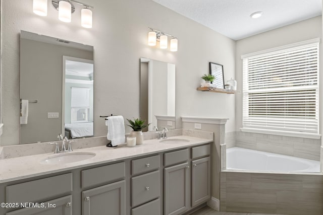 full bathroom featuring a garden tub, ensuite bath, a sink, and visible vents