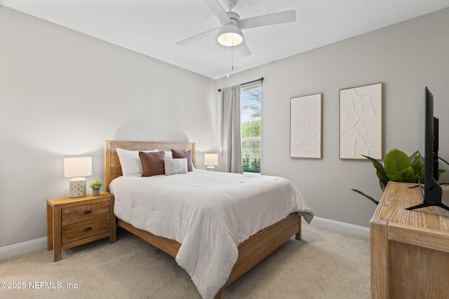 bedroom featuring light carpet, baseboards, and a ceiling fan