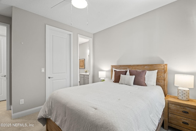 carpeted bedroom featuring ceiling fan, baseboards, and ensuite bathroom