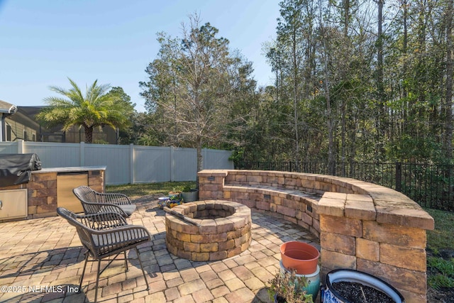 view of patio / terrace with an outdoor fire pit, grilling area, and a fenced backyard