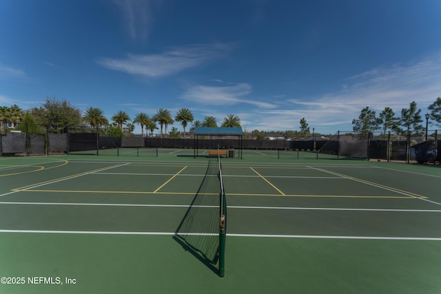 view of tennis court with community basketball court and fence