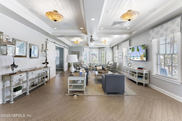 living room featuring crown molding, visible vents, plenty of natural light, and a barn door