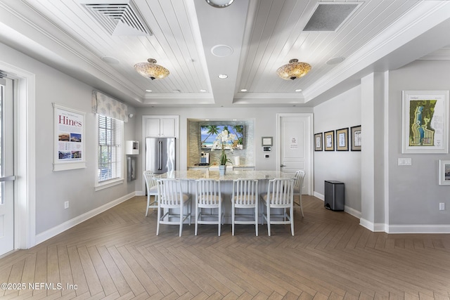 kitchen featuring light stone counters, a breakfast bar area, a kitchen island, and visible vents