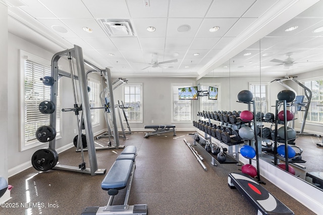 exercise room featuring a ceiling fan, a healthy amount of sunlight, visible vents, and baseboards