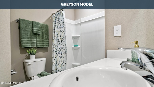 full bathroom featuring a textured wall, toilet, and a shower with shower curtain