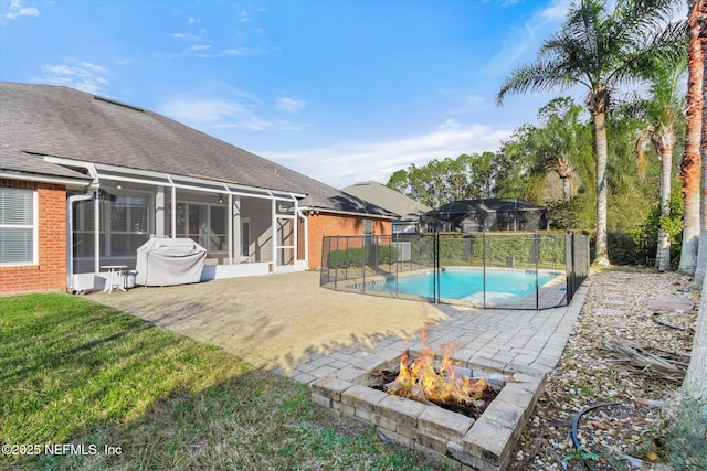 view of swimming pool featuring a fire pit, a fenced in pool, a lanai, a yard, and a patio area