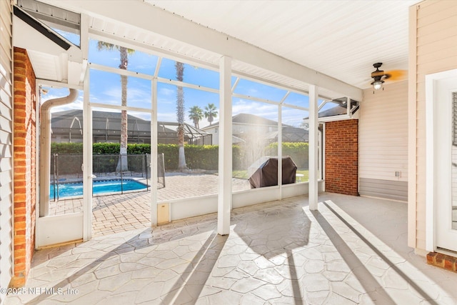 unfurnished sunroom featuring a ceiling fan