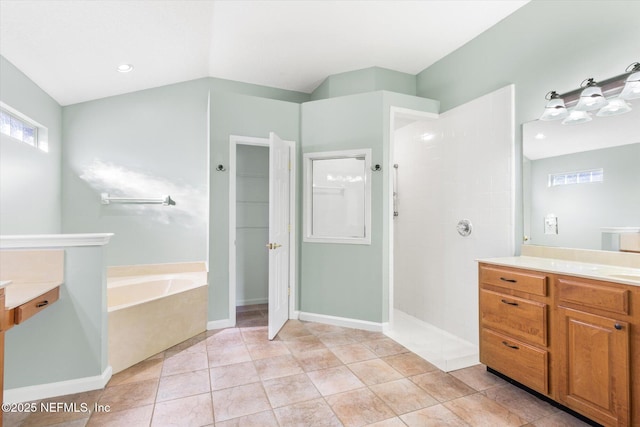 full bath with vaulted ceiling, vanity, a walk in shower, tile patterned flooring, and a bath