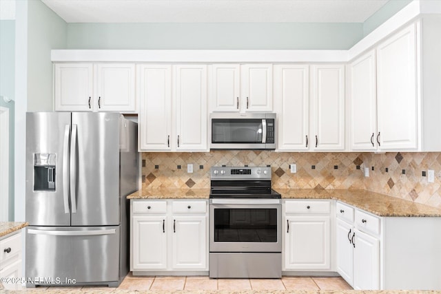 kitchen featuring stainless steel appliances, decorative backsplash, and white cabinets