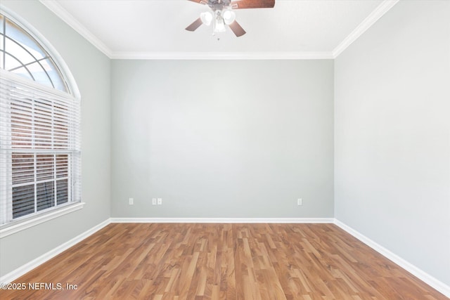 spare room with ornamental molding, wood finished floors, a ceiling fan, and baseboards