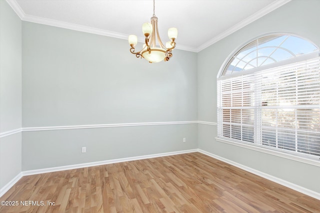 empty room with light wood-style floors, a notable chandelier, ornamental molding, and baseboards