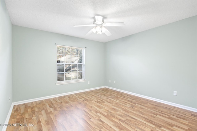 empty room with ceiling fan, light wood-style flooring, and baseboards