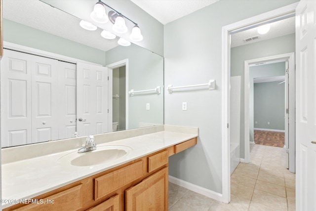 bathroom featuring visible vents, baseboards, toilet, tile patterned flooring, and vanity