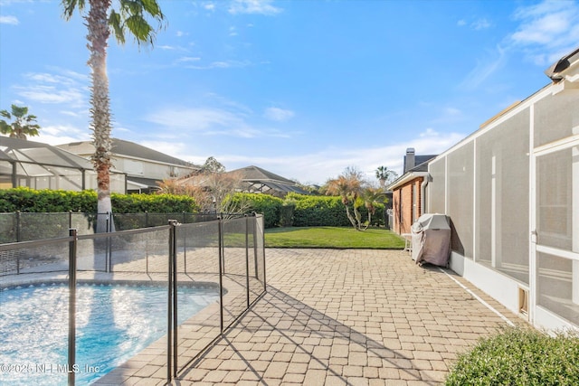 view of pool with a fenced in pool, fence, area for grilling, and a patio