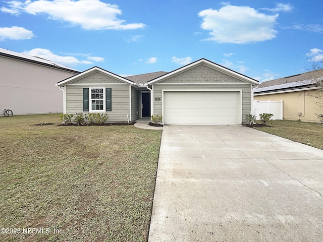 ranch-style house featuring a front yard, concrete driveway, and an attached garage