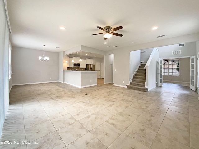 unfurnished living room with visible vents, baseboards, and stairs