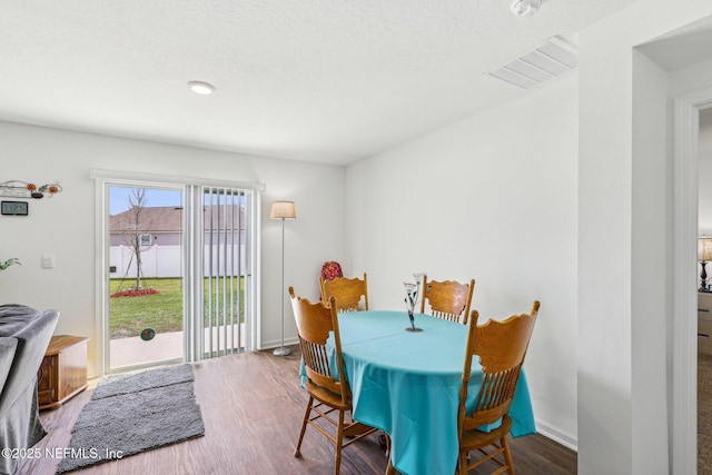 dining room with visible vents, baseboards, and wood finished floors