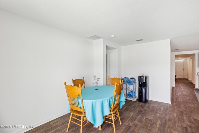 dining space featuring wood finished floors, visible vents, and baseboards