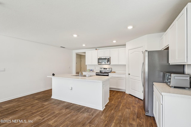 kitchen featuring recessed lighting, white cabinets, appliances with stainless steel finishes, dark wood-style floors, and an island with sink