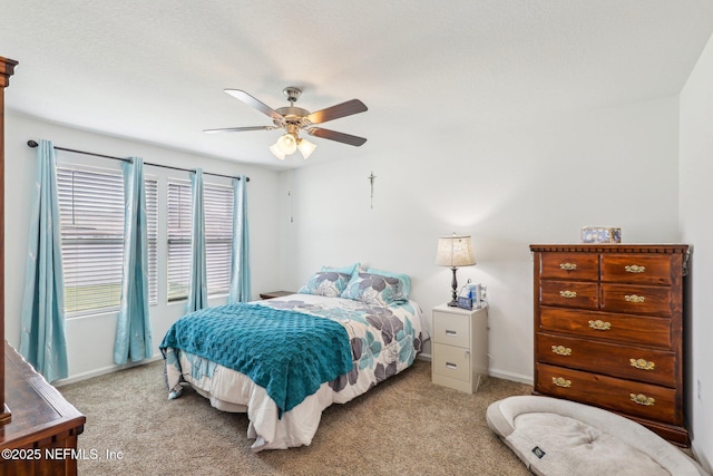 bedroom featuring light carpet, a ceiling fan, and baseboards