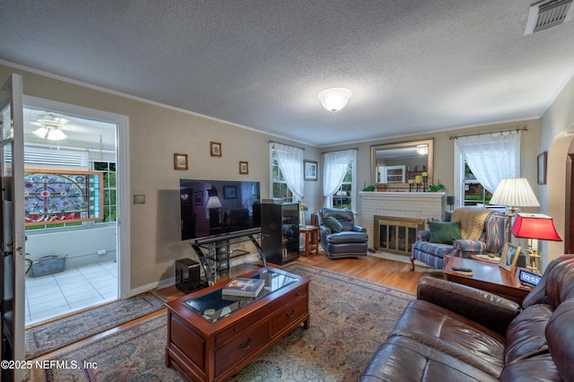 living area with crown molding, visible vents, and plenty of natural light