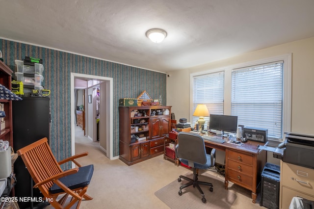 office featuring light colored carpet, a textured ceiling, baseboards, and wallpapered walls