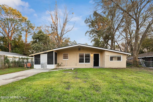 view of front of home featuring a front yard, brick siding, and fence