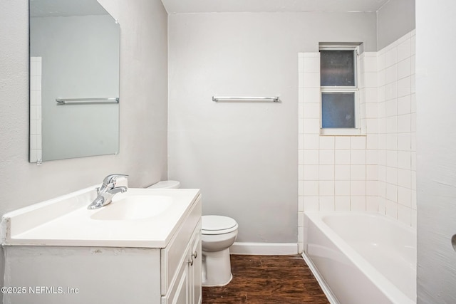 bathroom with vanity, wood finished floors, toilet, and baseboards