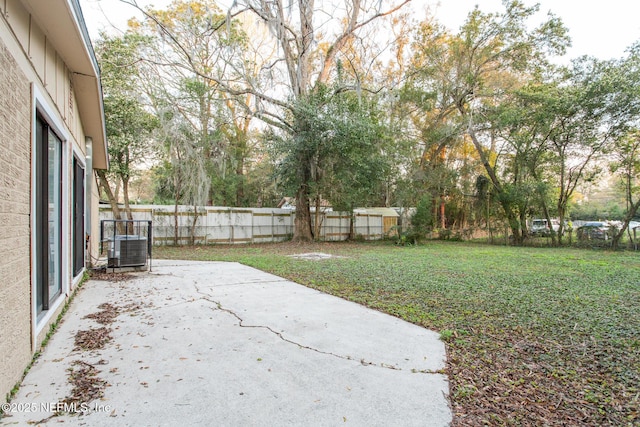 view of yard featuring a patio area, fence, and central air condition unit