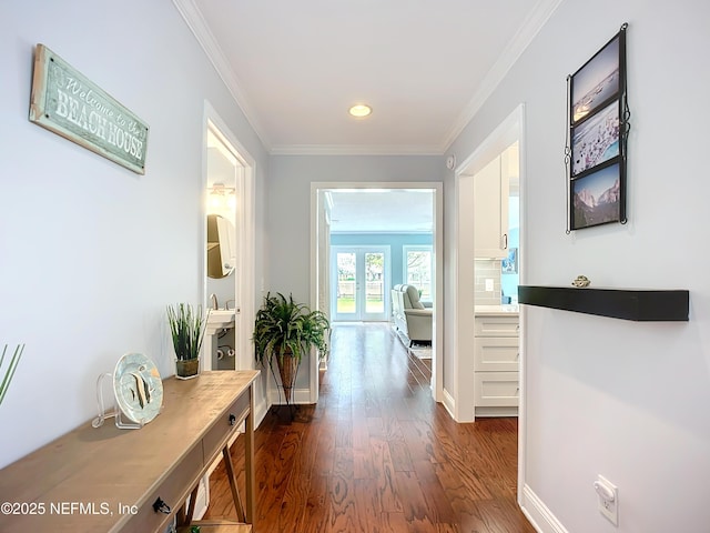 hallway with baseboards, dark wood finished floors, and crown molding