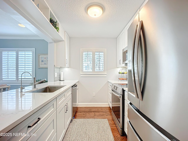 kitchen featuring white cabinets, appliances with stainless steel finishes, dark wood-style flooring, and a sink