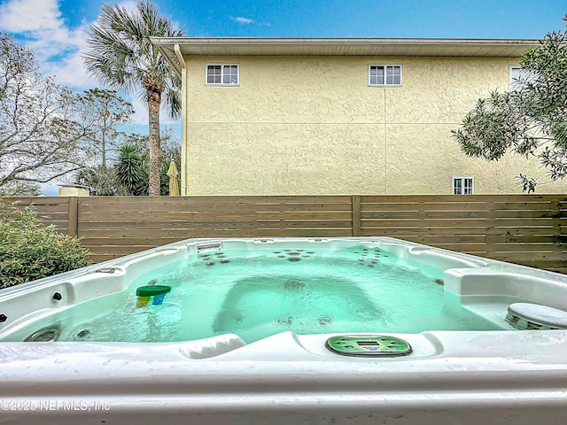 details with a jacuzzi and fence