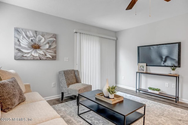 living area featuring ceiling fan, baseboards, and wood finished floors