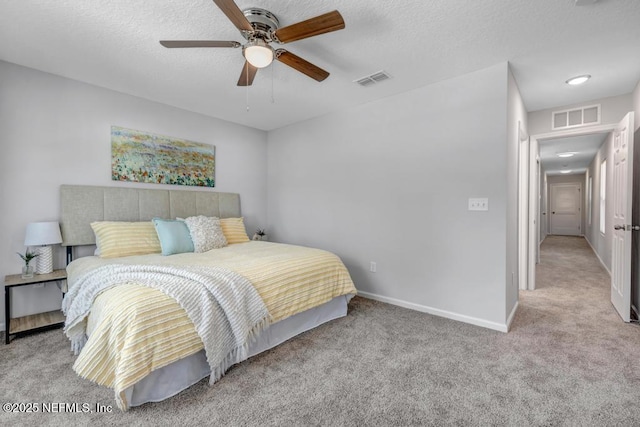 bedroom featuring light carpet, a textured ceiling, visible vents, and baseboards