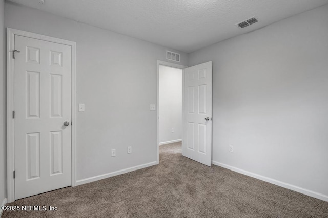 unfurnished bedroom featuring carpet floors, visible vents, and baseboards