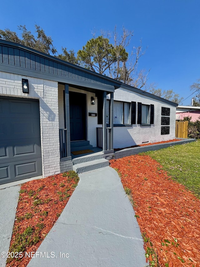 view of front of home featuring an attached garage and brick siding