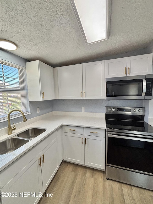 kitchen with white cabinets, appliances with stainless steel finishes, and light countertops