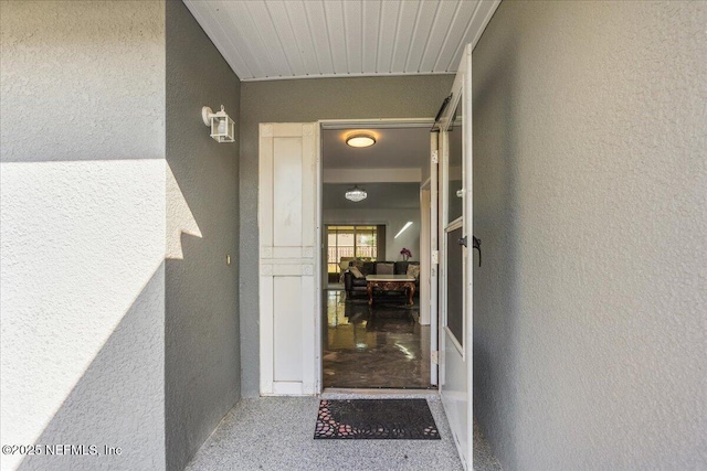 doorway to property featuring stucco siding