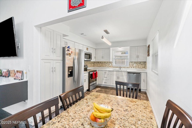 kitchen featuring stainless steel appliances, light countertops, a sink, and decorative backsplash