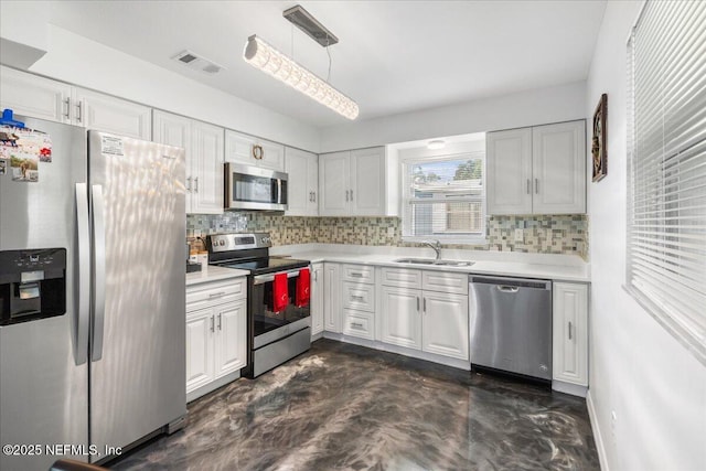 kitchen featuring visible vents, stainless steel appliances, a sink, and light countertops