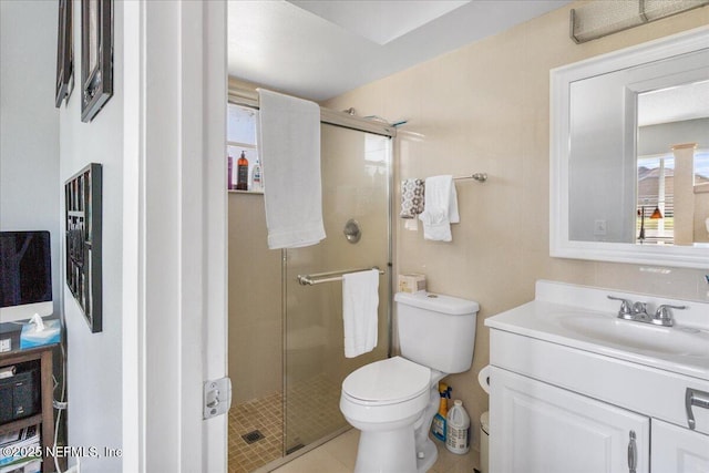 bathroom featuring a shower stall, toilet, and vanity