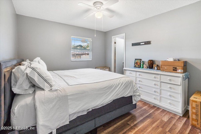 bedroom with a ceiling fan, a textured ceiling, and wood finished floors