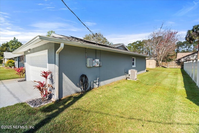 view of side of property with a garage, fence, a yard, concrete driveway, and stucco siding