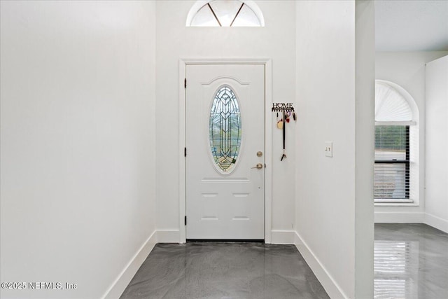 entrance foyer featuring concrete floors and baseboards