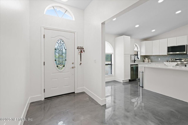 foyer entrance featuring lofted ceiling, recessed lighting, and baseboards