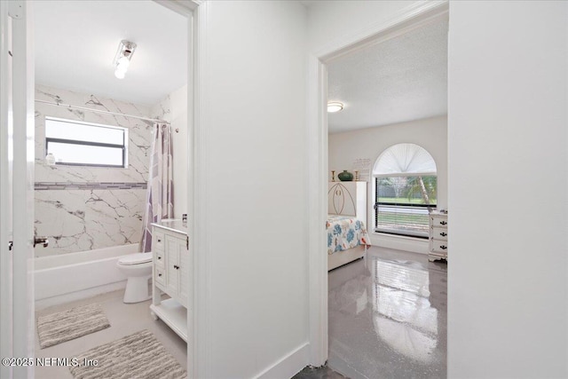 ensuite bathroom with shower / bath combination with curtain, toilet, ensuite bathroom, vanity, and a textured ceiling