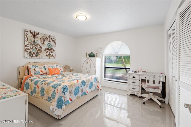 bedroom with a textured ceiling and a closet