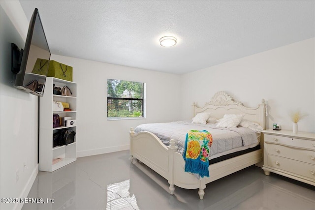 bedroom featuring a textured ceiling, concrete floors, and baseboards